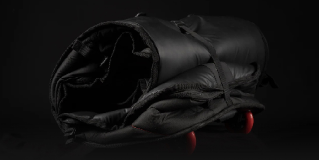Open end of a black board bag showing the interior, with a red wheel just visible
