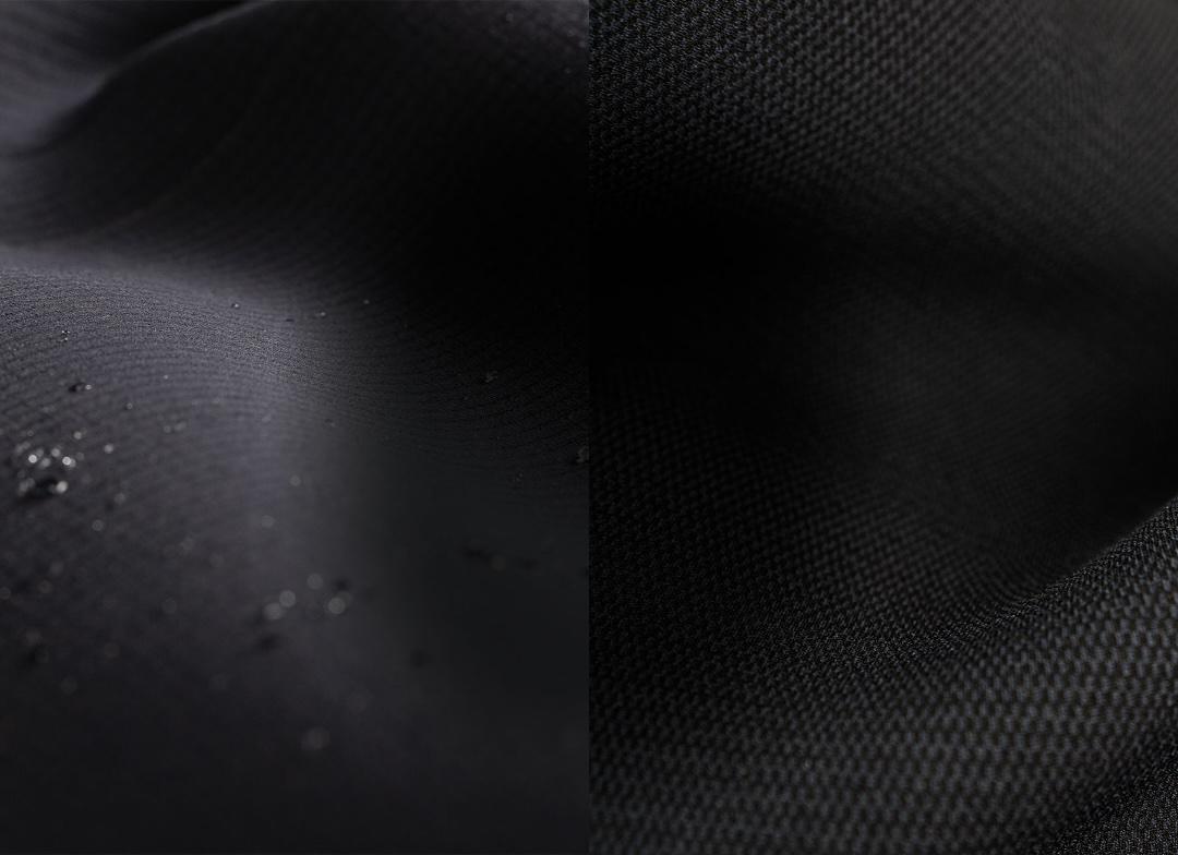 Close-up of black wetsuit neoprene with water droplets beside a fine mesh panel