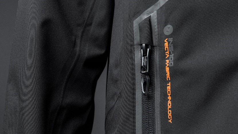 Close-up of a zipped chest pocket on a black jacket printed in orange with Vecta Fabric Technology